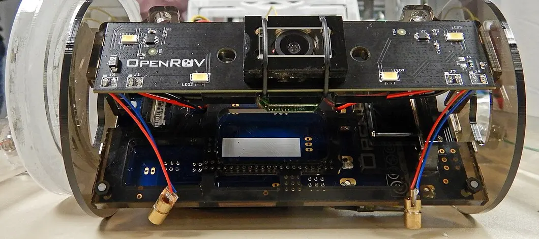Elektronikträger eines OpenROV mit Kamera, LEDs und Platinen zwischen zwei Acrylringen, bereit für den Einbau in die Druckröhre